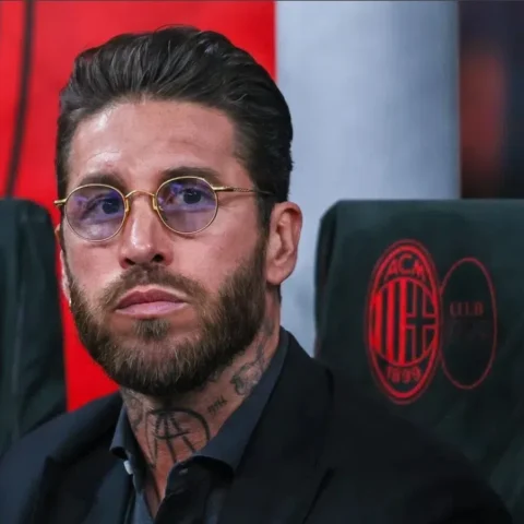 Sergio Ramos zit op een bankje langs het veld en kijkt geconcentreerd voor zich uit.