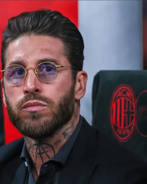 Sergio Ramos zit op een bankje langs het veld en kijkt geconcentreerd voor zich uit.
