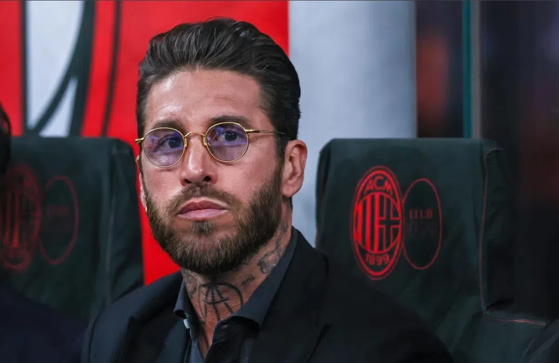 Sergio Ramos zit op een bankje langs het veld en kijkt geconcentreerd voor zich uit.