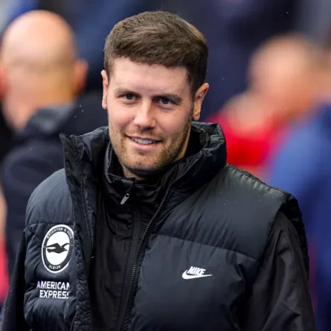 Fabian Hürzeler in een zwart Brighton-jack bij het veld.