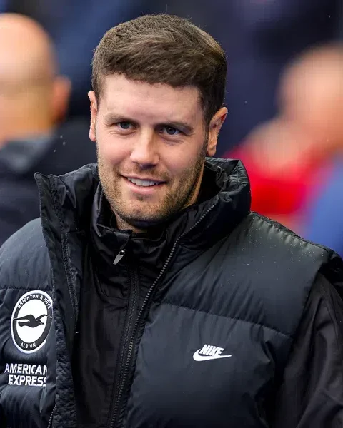 Fabian Hürzeler in een zwart Brighton-jack bij het veld.