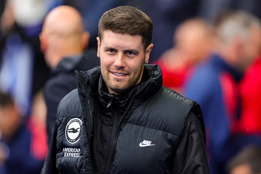 Fabian Hürzeler in een zwart Brighton-jack bij het veld.