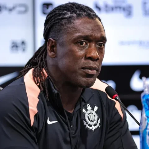 Clarence Seedorf spreekt op een persconferentie in een zwart trainingsjack van Corinthians.