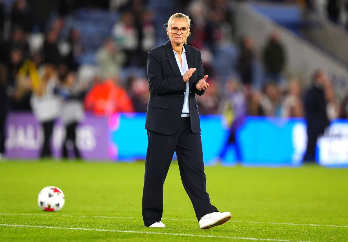 Sarina Wiegman applauds on the touchline during a football match.