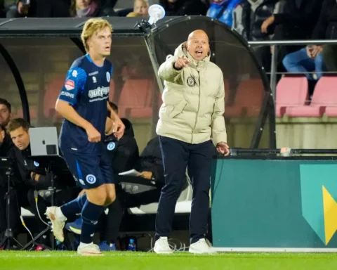 Trainer van De Graafschap geeft aanwijzingen langs de zijlijn tijdens een wedstrijd.