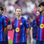 Barcelona-spelers staan op het veld in het thuisshirt.