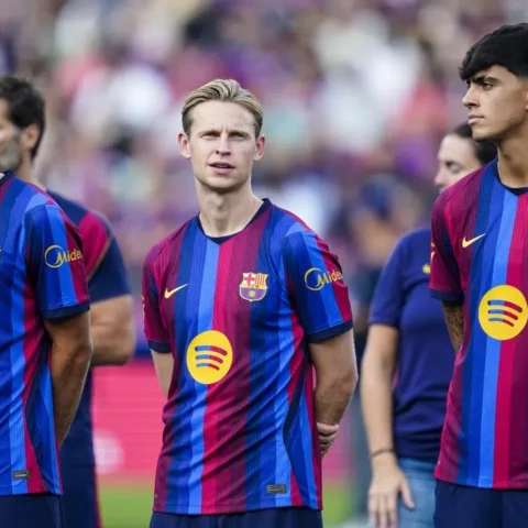Barcelona-spelers staan op het veld in het thuisshirt.