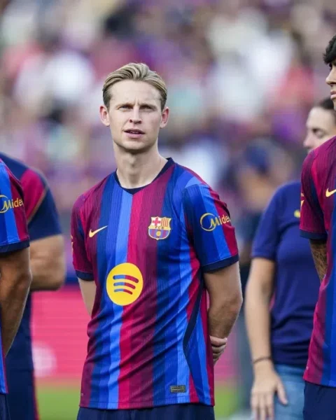 Barcelona-spelers staan op het veld in het thuisshirt.