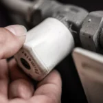Close-up van een hand die een mechanisch onderdeel vasthoudt.