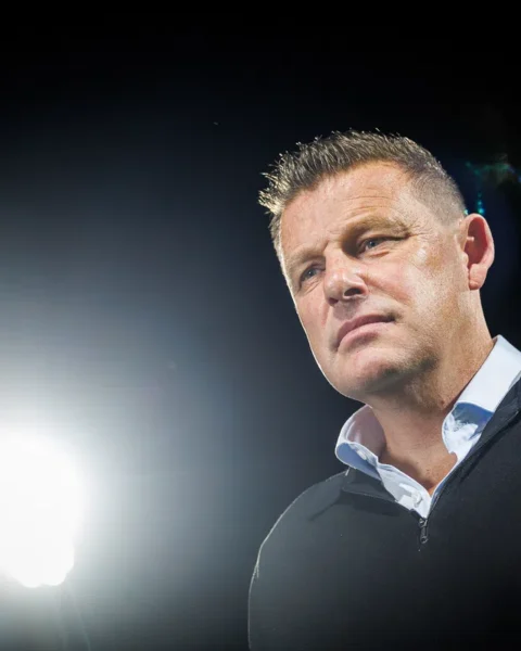 John Stegeman staat in een donkere setting met fel tegenlicht.