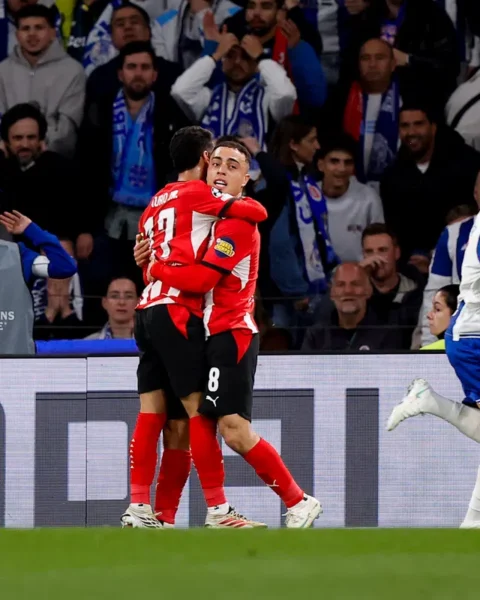 Sergiño Dest in een PSV-shirt loopt weg terwijl twee FC Porto-spelers elkaar omhelzen tijdens een Champions League-wedstrijd.