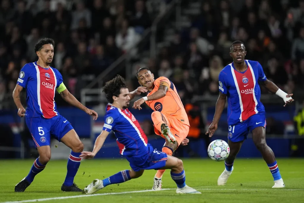 PSG-spelers en een Barcelona-speler in actie tijdens een Champions League-wedstrijd.