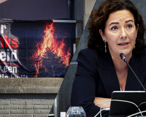 Femke Halsema spreekt bij een vergadering, naast een afbeelding van een brandende protestbanner.