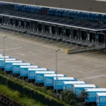 Albert Heijn-bezorgwagens staan geparkeerd bij een distributiecentrum met laadperrons.