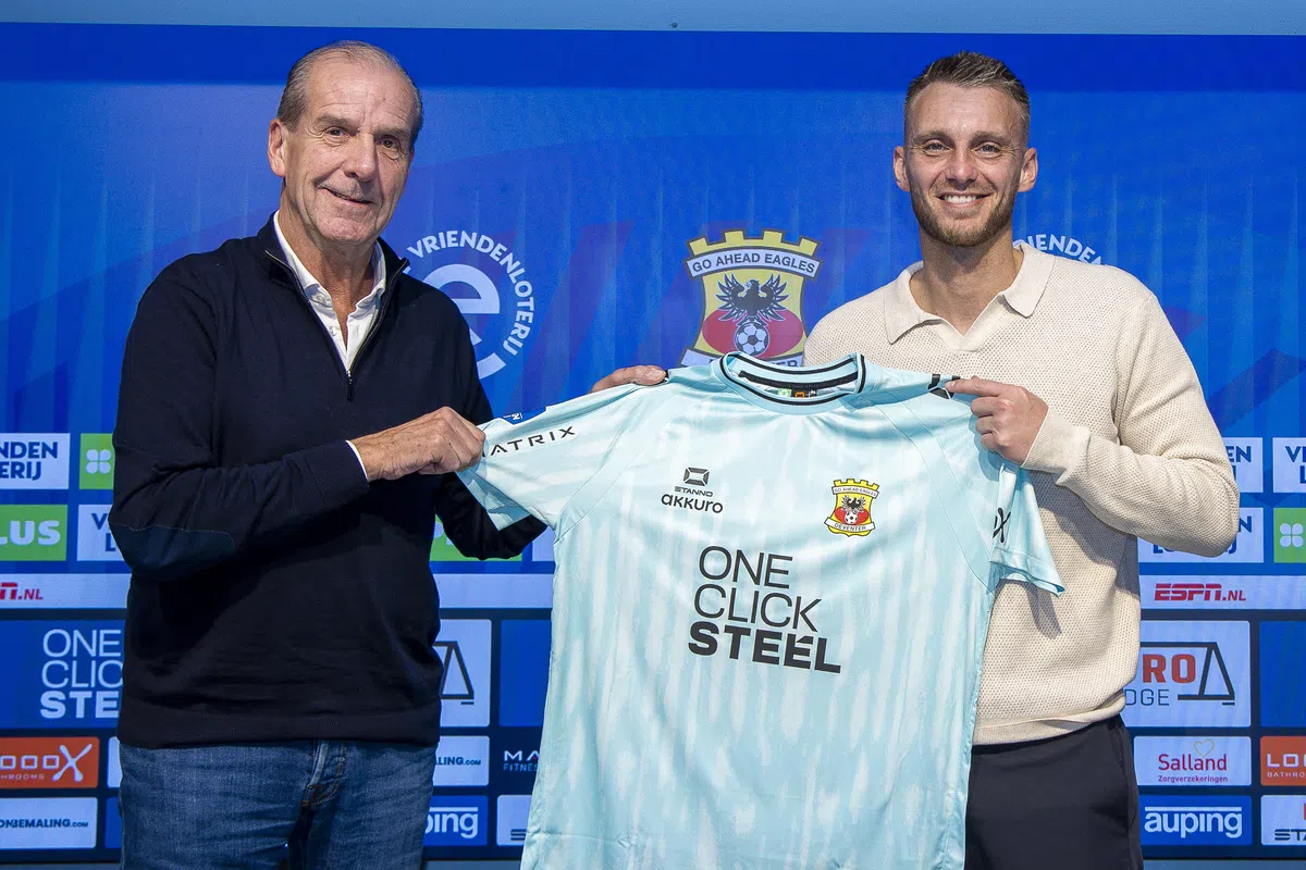 Jasper Cillessen poseert met een Go Ahead Eagles-shirt naast een clubvertegenwoordiger.
