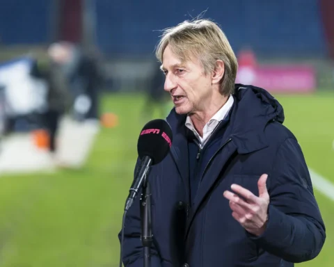 Adrie Koster spreekt met een ESPN-microfoon op het veld.