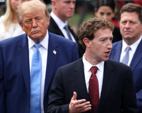 Mark Zuckerberg spreekt terwijl Donald Trump op de achtergrond staat, omringd door andere personen.